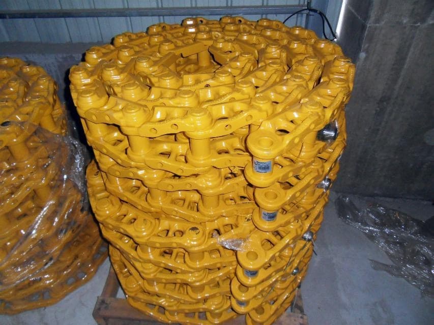 Bulldozer track chains stacked in tall coils