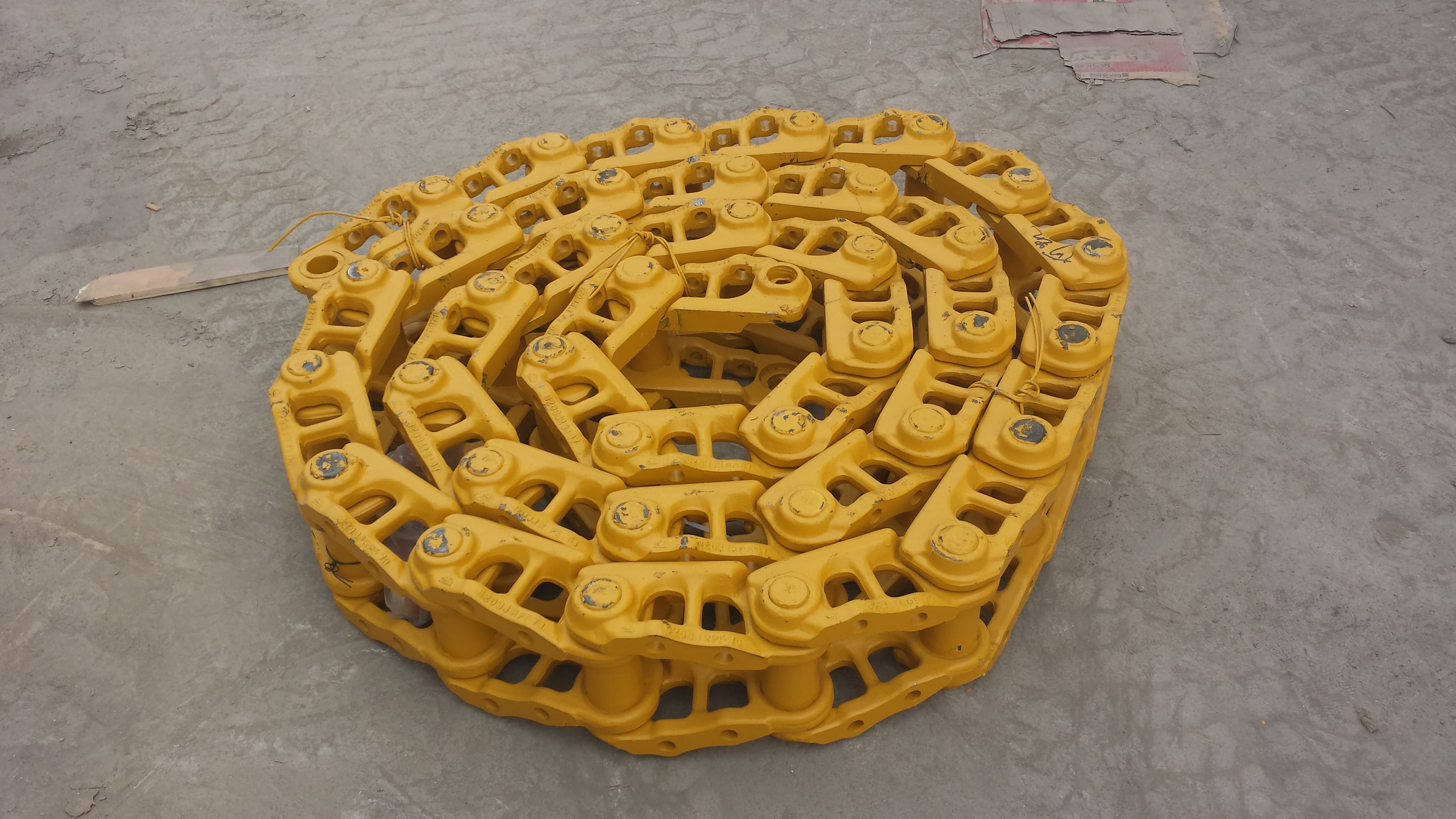 Bulldozer track chain coiled flat on the floor